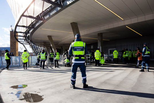 En ordningsvakt övervakar visiteringen utanför arenan