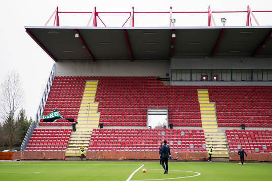 En Varbergs-supporter förbereder en banderoll på läktaren