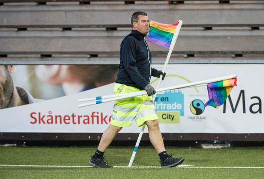 En vaktmästare samlar in de regnbågsfärgade