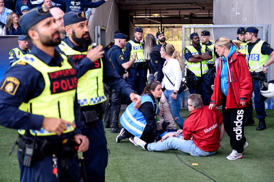 En supporter tas om hand av sjukvårdare
