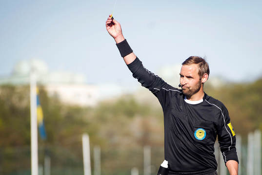 Domare Jim Petersson delar ut ett gult kort
