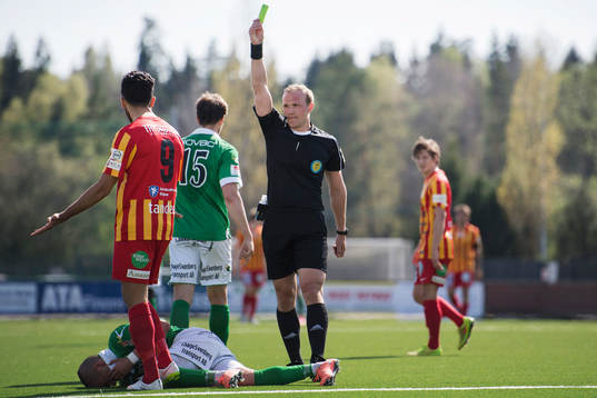 Domare Patrik Eriksson delar ut ett gult kort till