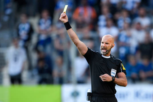 Domare Stefan Johannesson visar ett gult kort