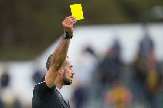 Domare Mohammed Al-Hakim ger en spelare gult kort