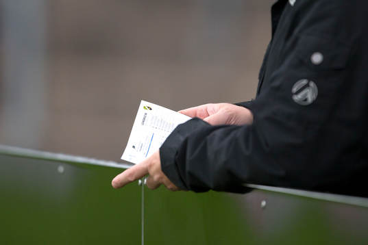En supporter läser i matchprogrammet