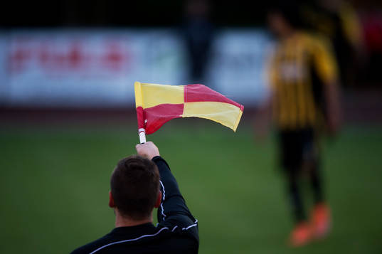 Assisterande domaren flaggar för offside i matchen i DM