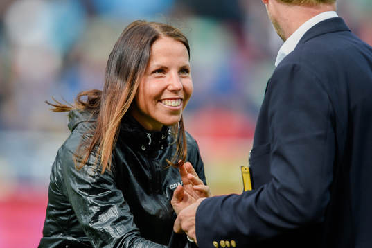 Charlotte Kalla delar ut matchtröja före fotbollsmatchen