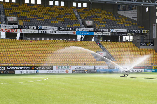 Vattning av konstgräset innan fotbollsmatchen i