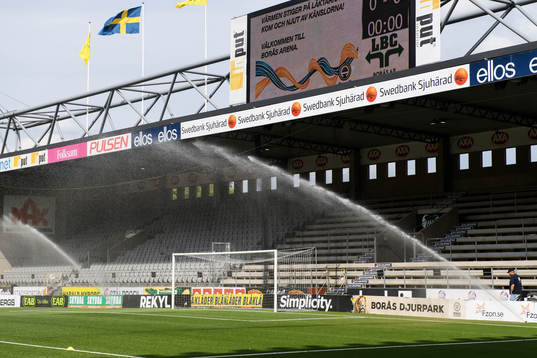 Vattning av konstgräset innan fotbollsmatchen i