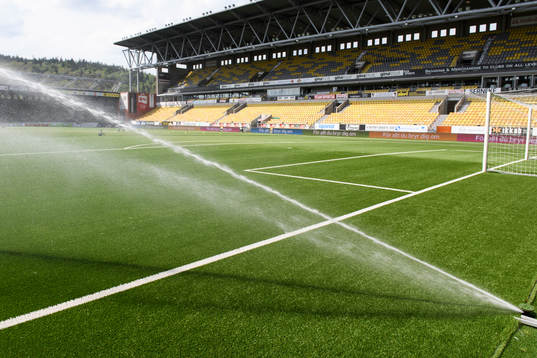 Vattning av konstgräset innan fotbollsmatchen i