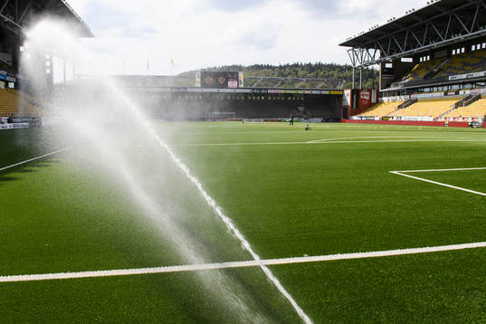 Vattning av konstgräset innan fotbollsmatchen i