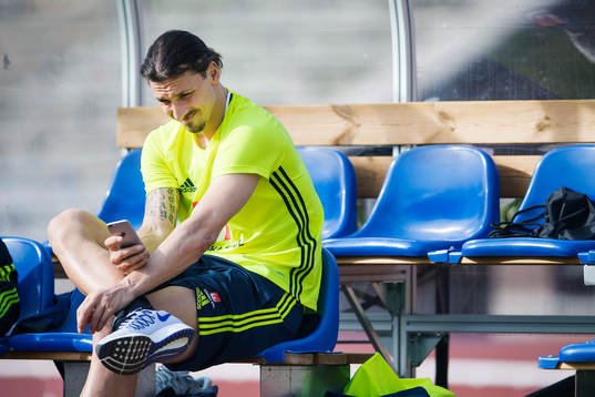 Sveriges Zlatan Ibrahimoivc tittar på sin telefon