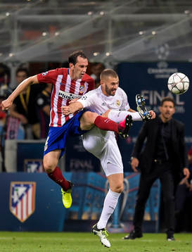 Atletico Madrids Diego Godin i kamp om bollen med Real