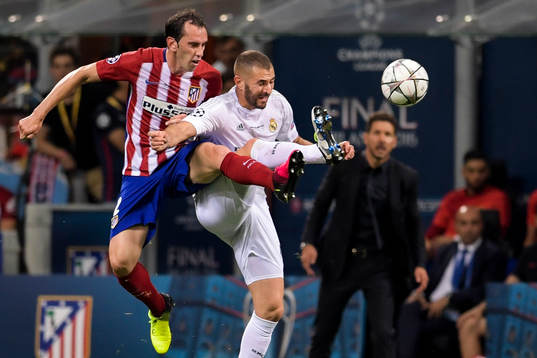 Atletico Madrids Diego Godin i kamp om bollen med Real