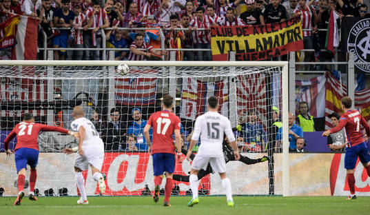 Atletico Madrids Antoine Griezmann (th) skjuter bollen i