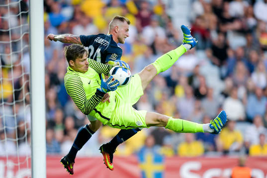 Sloveniens målvakt Vid Belec och Sveriges John Guidetti i