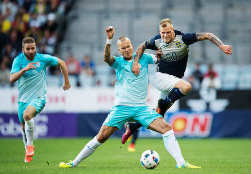 Sloveniens Aljaz Struna tacklar Sveriges John Guidetti