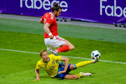 Sveriges Ludwig Augustinsson med en brytning Wales Gareth