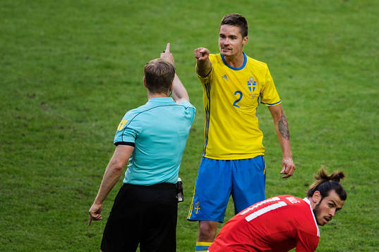 Sveriges Mikael Lustig reagerar mot domare Tobias Weiz