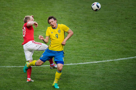 Sveriges Kim Källström i en duell mot Wales Jonathan