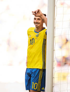 Sveriges Zlatan Ibrahimovic står vid en stolpe och ler