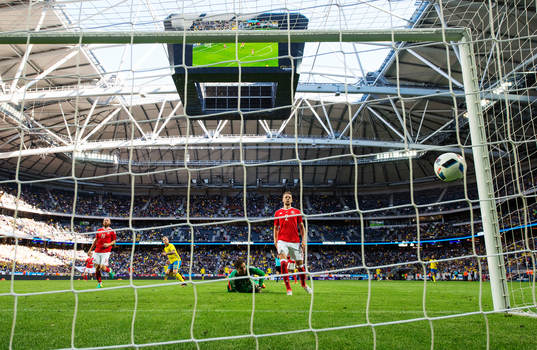 Sveriges John Guidetti skjuter in 3-0 bakom Wales målvakt