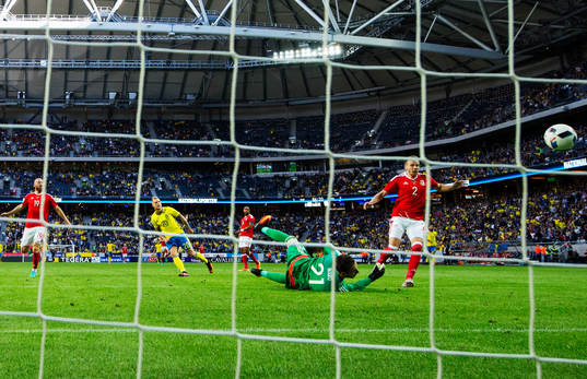 Sveriges John Guidetti skjuter in 3-0 bakom Wales målvakt