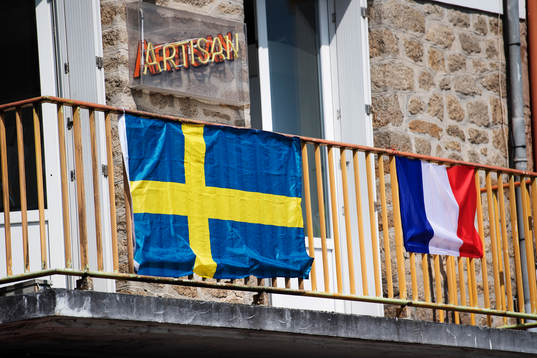 Sveriges och Frankrikes flagga hänger på en husfasad