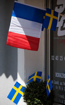 Svenska flaggor och Frankrikes flagga utanför en butik