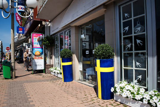 Blomkrukor målade i Sveriges färger står utanför en