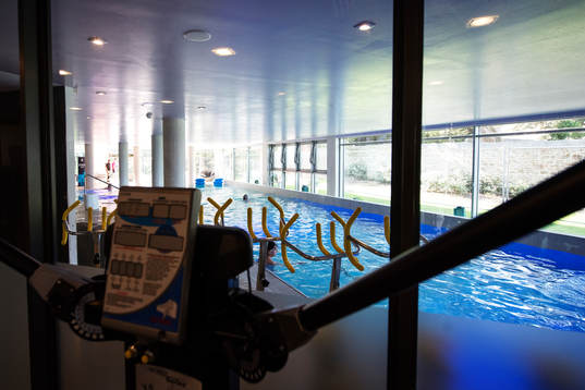 En inomhuspool sett från ett gym