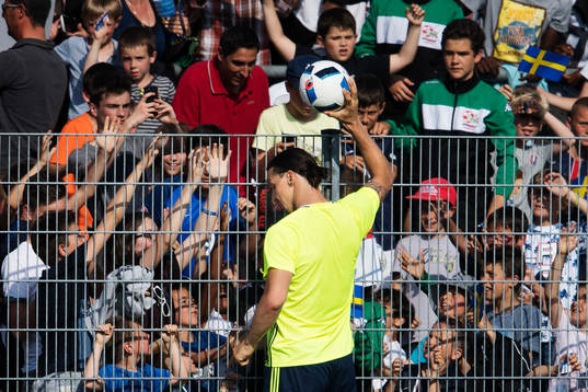 Zlatan Ibrahimovic ger en boll till en liten pojke