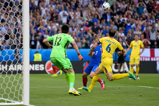 Frankrikes Antoine Griezmann och Rumäniens målvakt