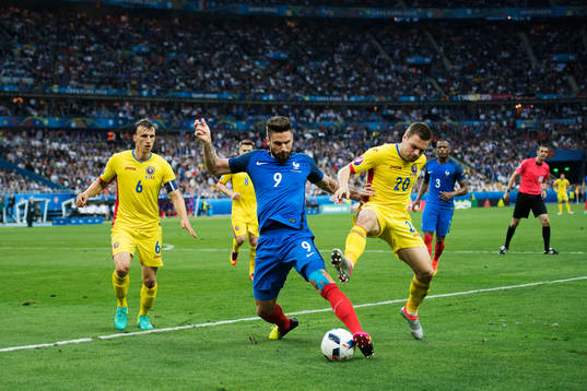 Frankrikes Olivier Giroud  i kamp om bollen med Rumäniens