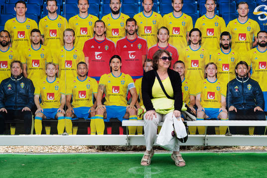 En kvinna sitter i en busskur inredd med en lagbild av