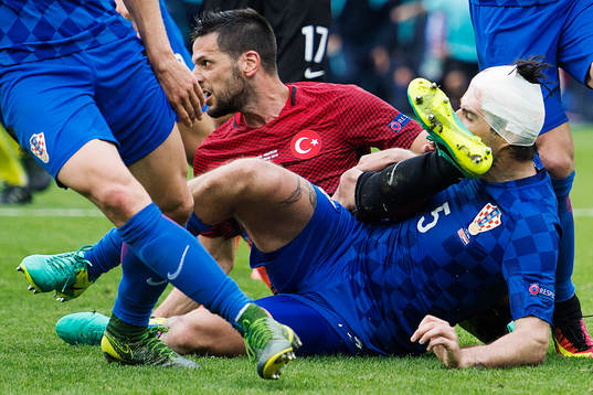 Kroatiens Vedran Corluka får en fot av Turkiets Hakan
