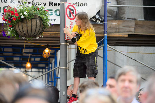 A Pittsburgh Penguins fan hangs from a street sign to try