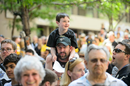 A young pittsburgh Penguins fan tries to get a better view