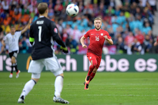 Polens Jakub Blaszcykowski springer mot Tysklands målvakt