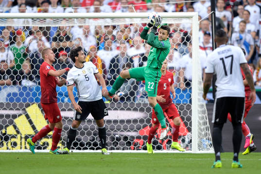 Polens målvakt Lukasz Fabianski räddar bollen i
