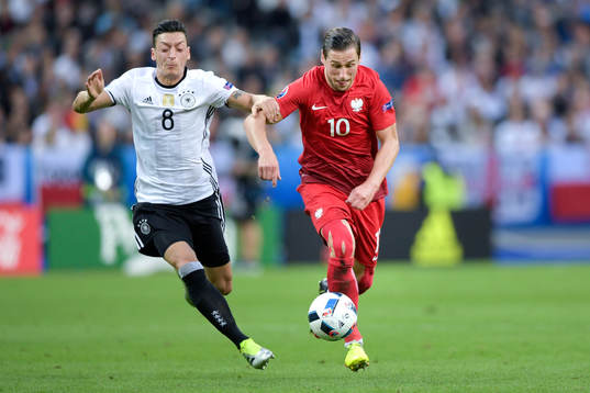 Tysklands Mesut Özil jagar Polens Grzegorz Krychowiak i