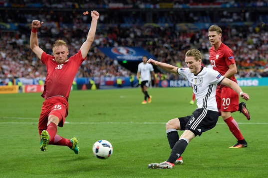 Polens Kamil Glik försvarar mot Tysklands André Schurrle