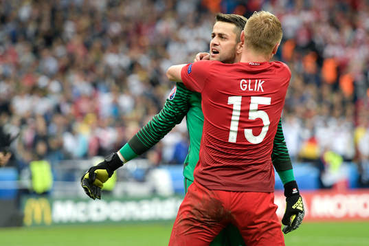 Polens målvakt Lukasz Fabianski kramas om av Kamil Glik