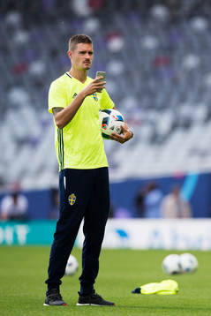 Mikael Lustig tar bilder med en mobiltelefon när han är