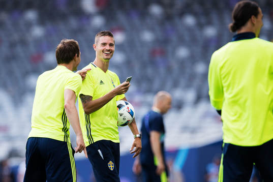 Mikael Lustig tar bilder med en mobiltelefon när han är