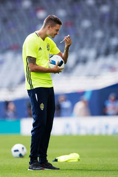 Mikael Lustig tittar på en mobiltelefon när han är med
