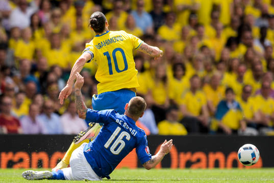 Sveriges Zlatan Ibrahimovic tacklas av Italiens Daniele De