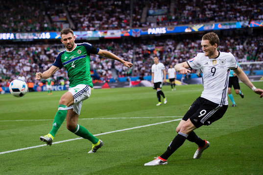 Tysklands André Schurrle mot Nordirlands Gareth McAuley  i