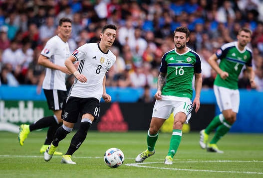 Tysklands Mesut Özil och Nordirlands Oliver Norwood i