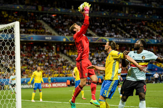Sveriges målvakt Andreas Isaksson plockar bollen framför